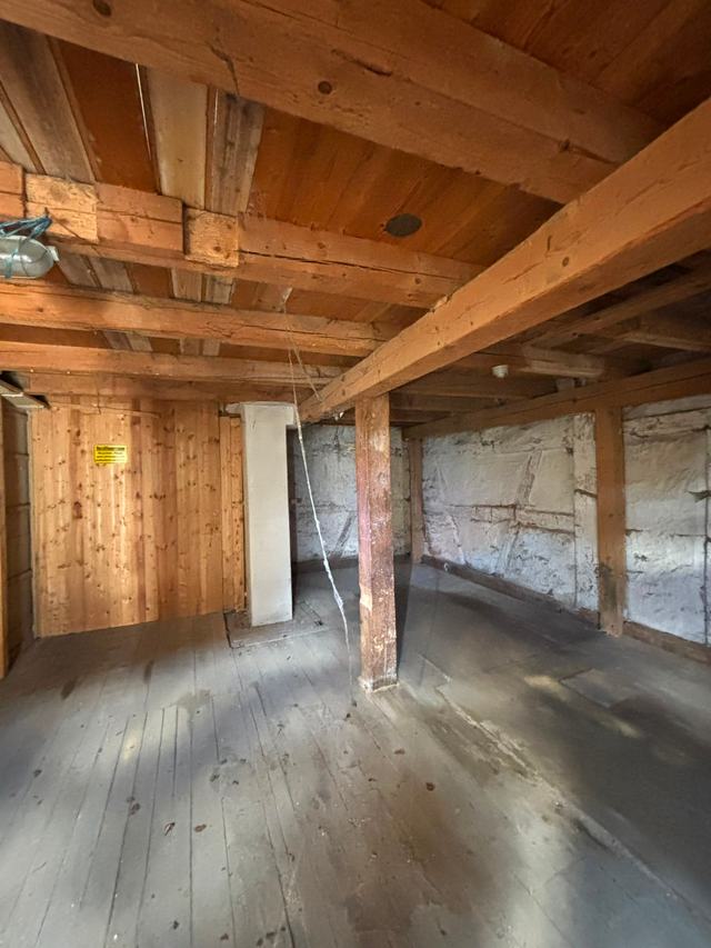 Leer geräumter Raum in einem Altbau mit Holzbalkendecke und Holzboden